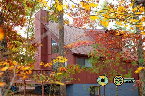 a red house with a deck in the woods at Villa #91 in Basye