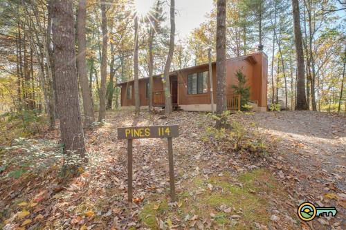 a house in the woods with a sign in front of it at Villa #114 in Basye