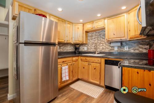 a kitchen with wooden cabinets and a stainless steel refrigerator at Aspen East Unit #231: Slippery Slope in Basye