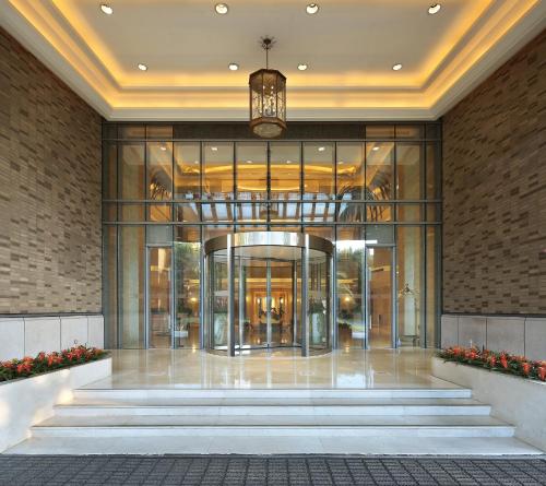 a lobby of a building with glass doors and stairs at Shanghai Dongjiao State Guest Hotel in Shanghai