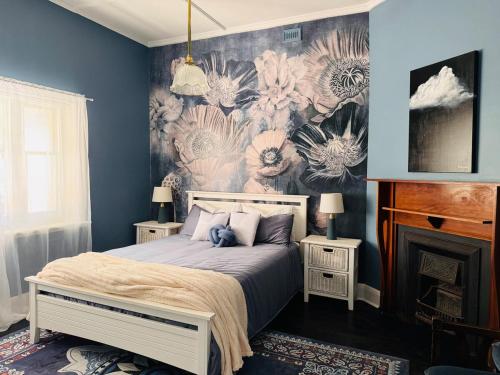 a bedroom with a bed with a floral wallpaper at Forrest House Victor Harbor in Victor Harbor