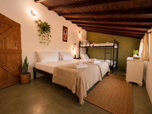a bedroom with two beds and a bunk bed at Pousada Mojomar Buzios in Búzios