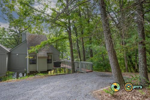 a house with a driveway next to a tree at Lakeview 85B: Treehouse Mountain in Basye