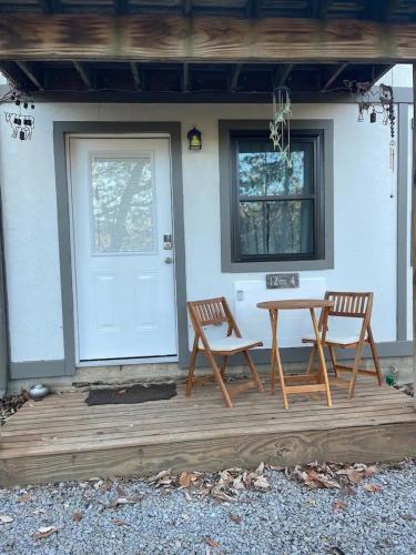a patio with two chairs and a table and a door at Lakeview 12B: Casa Uno Condo in Basye