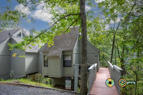 a house with a wooden walkway in the woods at Lakeview 85B: Treehouse Mountain in Basye