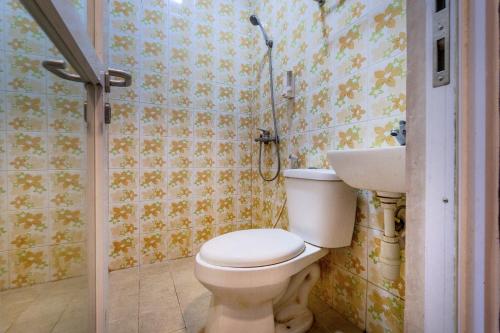 a bathroom with a toilet and a sink at Hotel Dahlia By ARBA in Jakarta