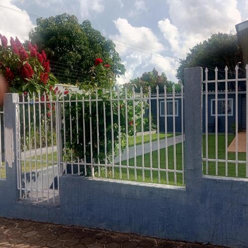 a white fence with a gate in a yard at Suíte completa na Região do Lago in Cascavel