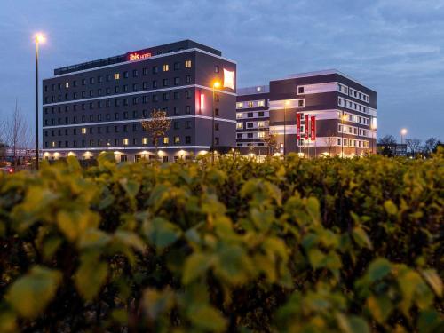 a building and a field of plants in front of a building at ibis Duesseldorf Airport in Düsseldorf