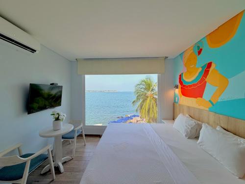 a bedroom with a large bed with a view of the ocean at Hotel Caribbean Cartagena in Cartagena de Indias