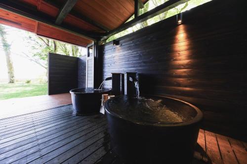 a bathroom with a tub and a sink on a deck at marinoe organic resort - Health and Stay - A Private Lakeside Villa at Lake Yamanaka, Blessed by the Spirit of Mount Fuji in Yamanakako