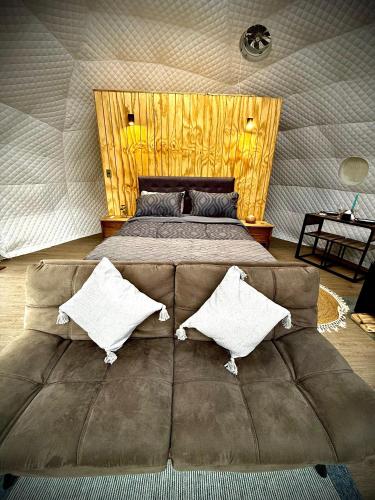 a large couch in a bedroom with a bed at APPA Glamping Domo 2 Jacuzzi privado in El Quisco