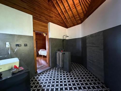 a bathroom with a black and white tiled floor at Taman Swarga Villa Resort & Spa Sidemen in Sidemen