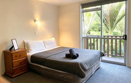 a bedroom with a bed and a large window at Cube Lite Apartments in Hamilton