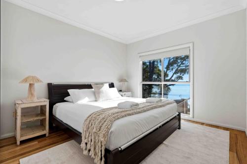 a bedroom with a large bed and a window at Sunkissed & Studio in Vincentia