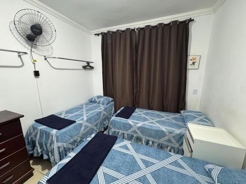 a room with two beds and a fan at Casa 2 dorms com garagem e Wi-Fi in São Paulo