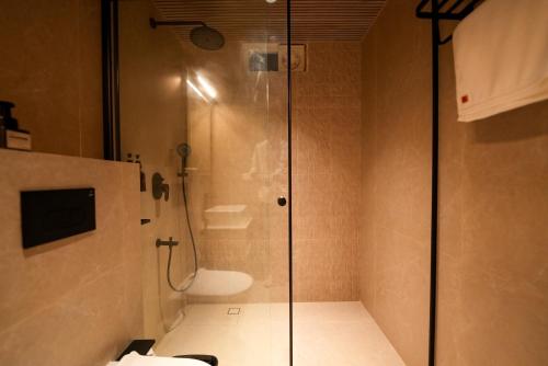 a bathroom with a shower with a glass door at Hotel California in Bangalore