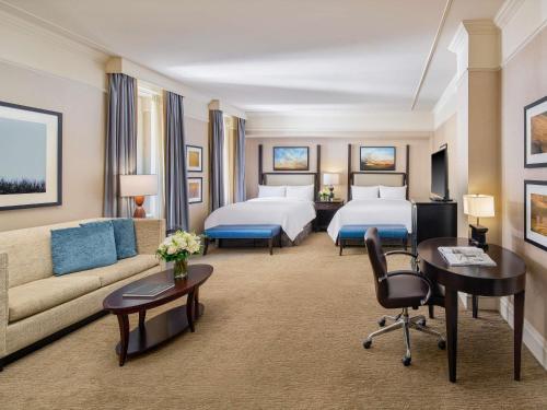 ein Hotelzimmer mit zwei Betten und einer Couch in der Unterkunft Fairmont Palliser in Calgary