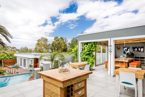 an outdoor patio with a table and chairs and a pool at Bloemenzee Boutique B&B in Gordonʼs Bay