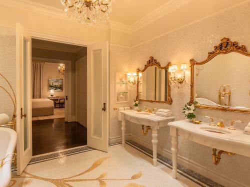 a bathroom with two sinks and a large mirror at The Plaza, A Fairmont Hotel in New York