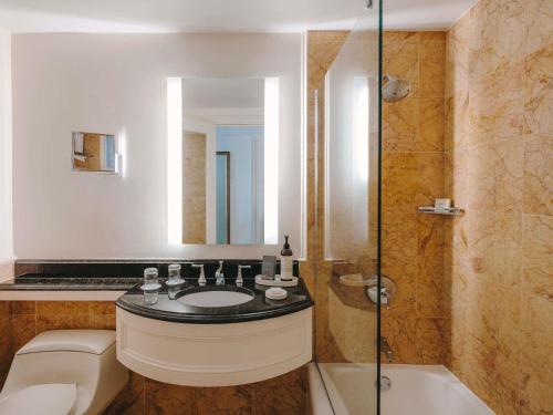 a bathroom with a sink and a shower and a toilet at Hamilton Princess & Beach Club A Fairmont Managed Hotel in Hamilton