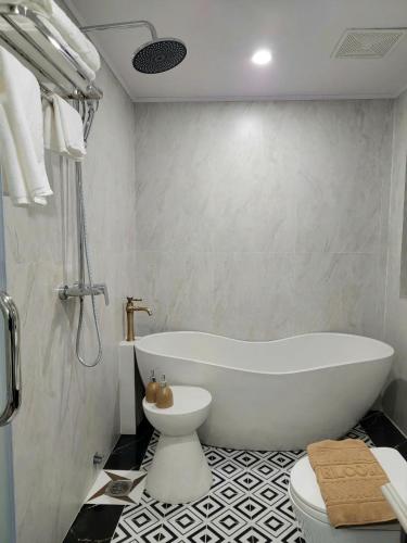 a bathroom with a white tub and a toilet at Anara Sapa Hotel in Sapa