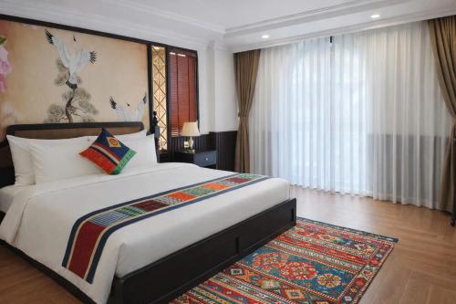 a bedroom with a large bed and a rug at Anara Sapa Hotel in Sapa