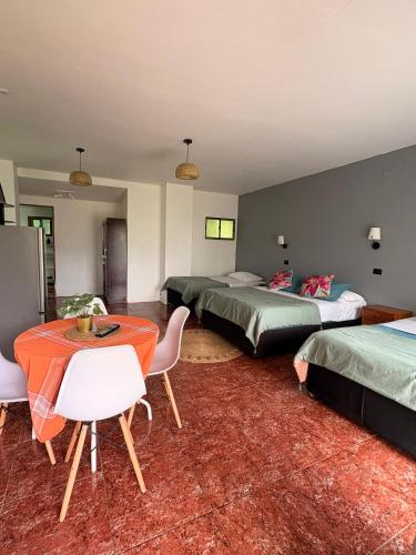 a room with three beds and a table and chairs at Cabañas Honu Nui Inn in Hanga Roa