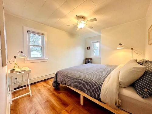 a bedroom with a bed and a ceiling fan at Shorebreak Cottage in North Kingstown