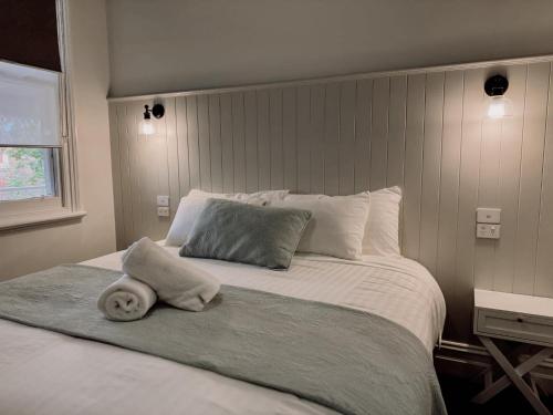 a white bed with a towel on top of it at Honeysuckle Inn - Violet Town in Violet Town