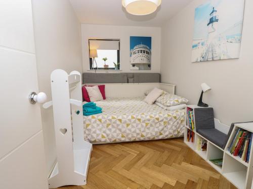 a small bedroom with a bed and a book shelf at Aquanaut in Cowes