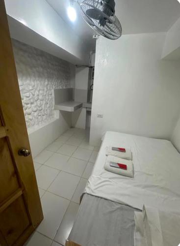 a small room with a bed with two towels on it at RF Hotel Transient House in Bangued