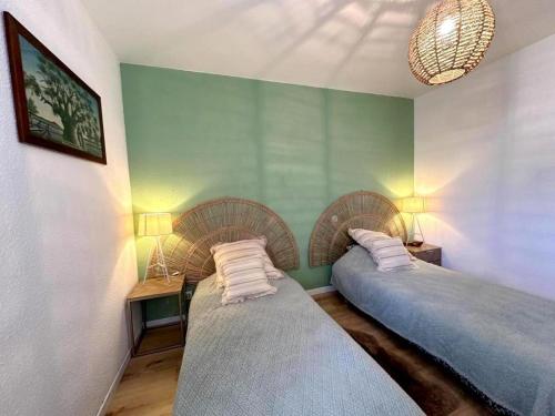 two beds in a room with green walls at Le gîte sabotier in Nerbis