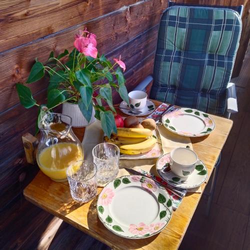 a table with plates and cups and a vase with flowers at Alpbachblick in Alpbach