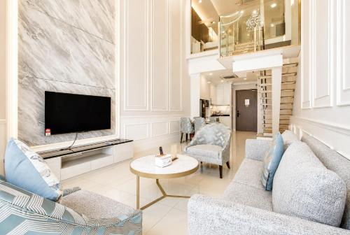 a living room with a couch and a tv at Societe Hartamas in Kuala Lumpur