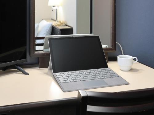 a laptop computer sitting on top of a desk at Tabist Hotel New Osamura Sabae Inter in Fukui