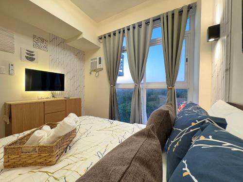 a bedroom with a couch and a large window at Ocean Garden Villas 7th Floor - Road Side in Boracay