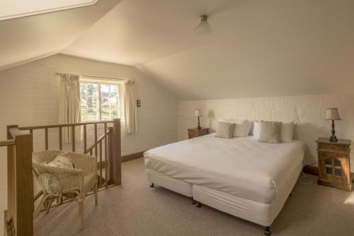 a bedroom with a large bed and a chair at Woolmers Estate in Longford