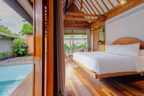 ein Schlafzimmer mit Bett und ein Swimmingpool in der Unterkunft Ayom Java Village Solo in Solo