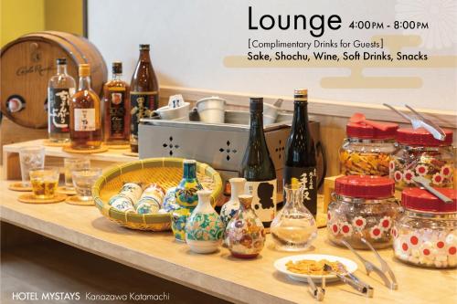 a counter with bottles of wine and dishes on it at HOTEL MYSTAYS Kanazawa Katamachi in Kanazawa