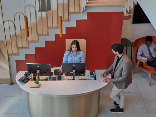 a man standing in front of a desk with two computers at Adagio access Brussels Delta in Brussels