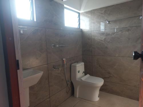 a bathroom with a toilet and a sink at Serene Enclave in Nedumbassery