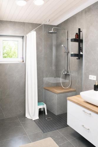 a bathroom with a shower and a sink at Aukštupio Vila in Aukštupėnai