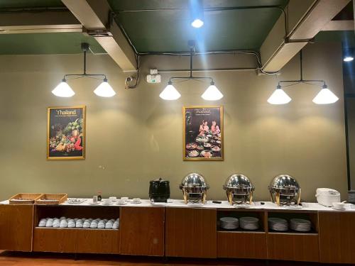 a restaurant with a counter with plates and bowls at Work Den Chiangrai in Chiang Rai