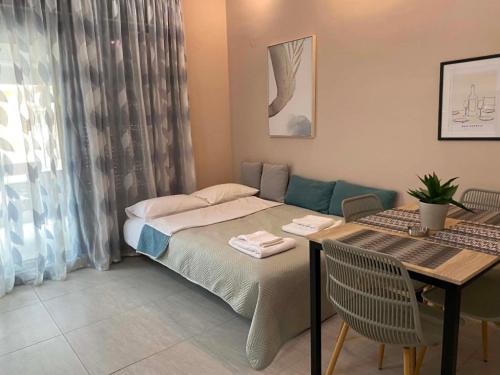 a bedroom with a bed and a table with chairs at Modern Living Experience in Nea Peramos