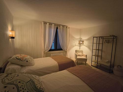 a hotel room with two beds and a window at Villa Argonaute in Saint-Tropez