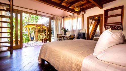 a bedroom with a large bed and a patio at Carpe Diem Casitas & Villas Mazunte in Mazunte