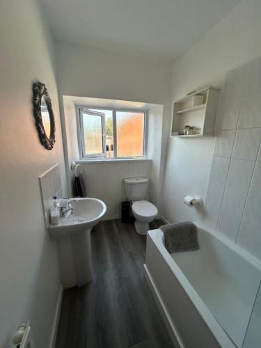 a white bathroom with a toilet and a sink at No 28B St Benedict in Glastonbury