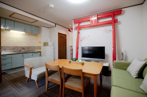 a living room with a table and a kitchen at Ponpon Railway House in Kyoto