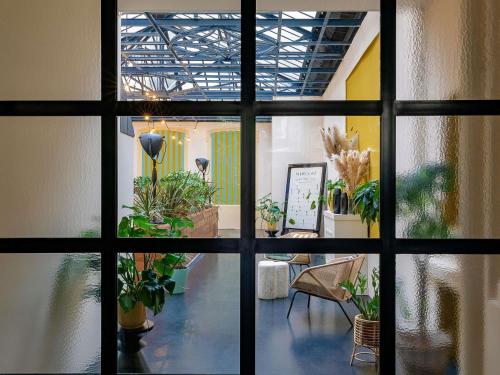 a view through a window of a room with potted plants at Mercure Grand Hôtel Metz Centre Cathédrale in Metz