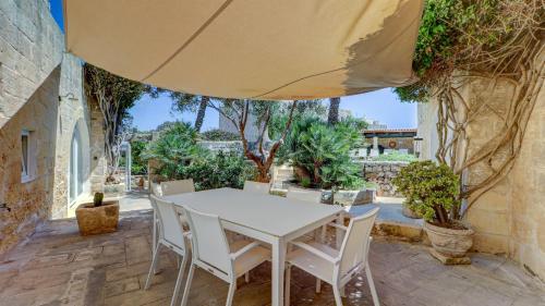 a white table and chairs on a patio at Wonderful 4BR Farmhouse with Private Pool in Rabat